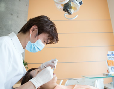 歯科医師が患者さんの口腔内を治療している様子の写真。